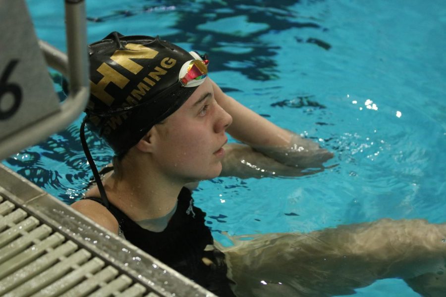 Sophomore Olivia Neunaber looks up at the clock to check her time after her race.