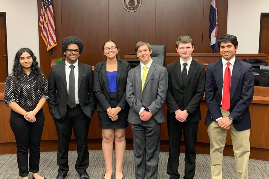 The FHN Mock Trial team stands for a group photo, in front of a judge's bench, after a successful meet.