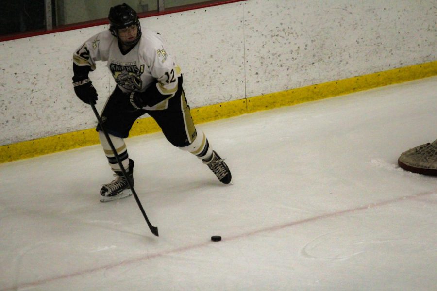 Junior Blaine Longmore skates away from the goal after stealing the puck. Longmore was injured by crashing into the sideboards. The broken clavicle resulted in Longmore getting surgery to insert a titanium plate in his shoulder to fix the broken bone.