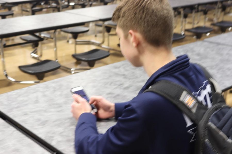 Senior Tim Buchanan sits and browses on a new social media app called TikTok. Buchanan has enjoyed using the new app and wants more people to join in on the new app.