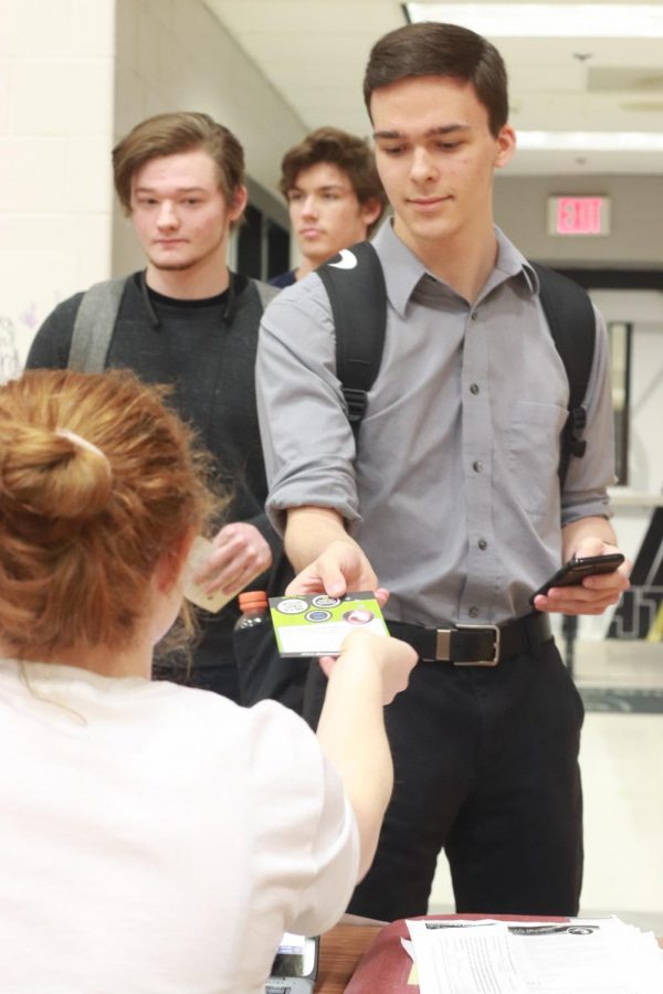 Senior Brandon Brophy hands in his permission slip to senior Autumn Schrader to sign into the blood drive. Students were given passes that determined the time that they would get their blood drawn. This was done so there wouldn’t be a large line of students waiting. Normally blood drives have around 26 students and teachers donate but this year FHN had 159.