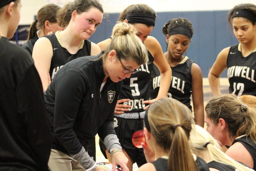 Coach Dawn Hahn discusses strategy with the girls team during a game against FHC. The Spartans would win the game 58-25.