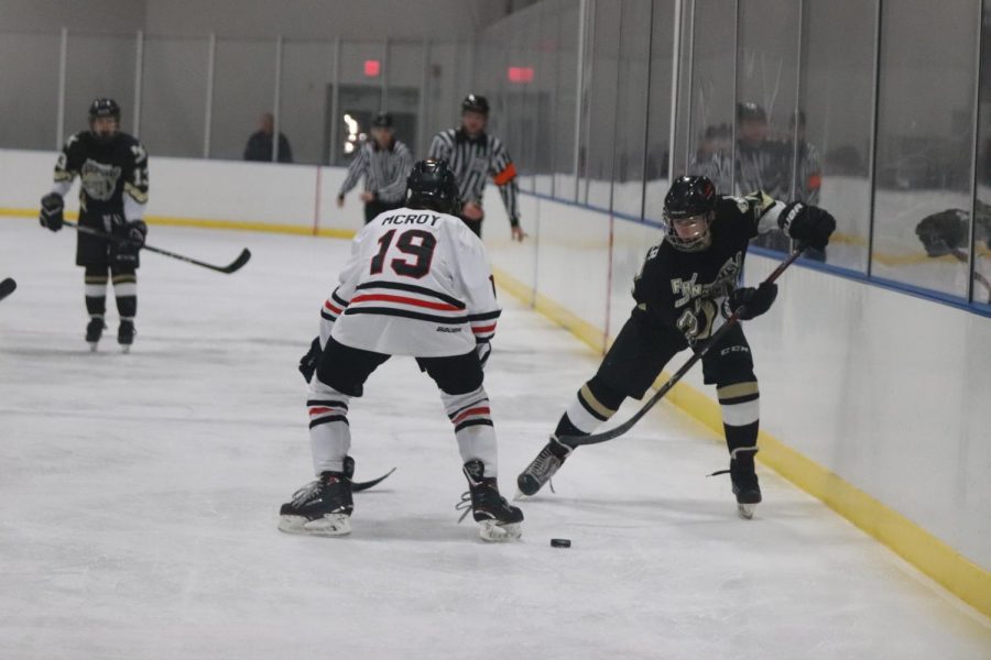 Freshman Derek Archer passes the puck up the boards. As a freshman it was Archer's first year on the team. Archer played center for the Knights this season. 