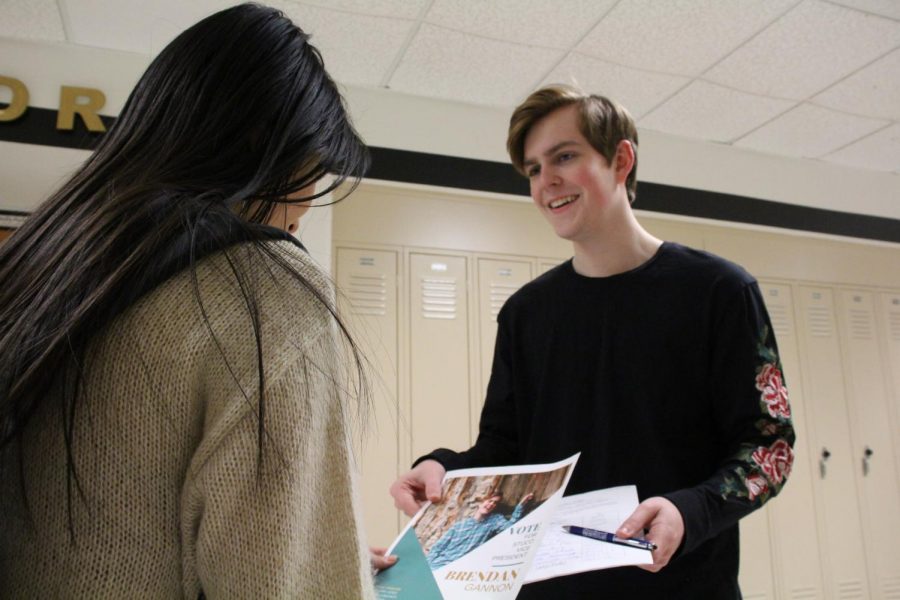 Brendan Gannon hands a student a flyer for the upcoming STUCO elections. Gannon wanted to become vice president instead of becoming president a second year. Every year, returning StuCo members are allowed to run to be an officer the following year.