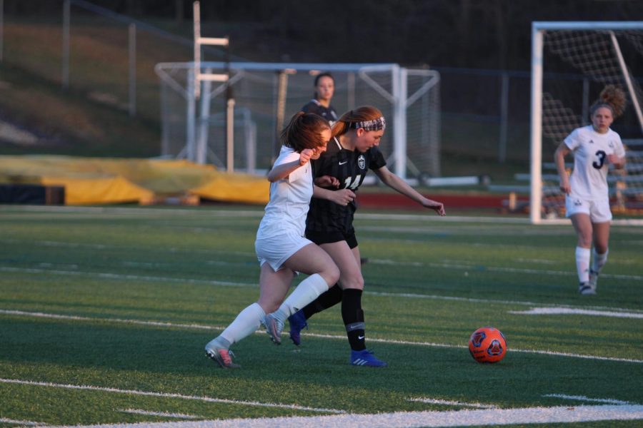 Senior Megan Crain fights with an FHC player for possession of the soccer ball.