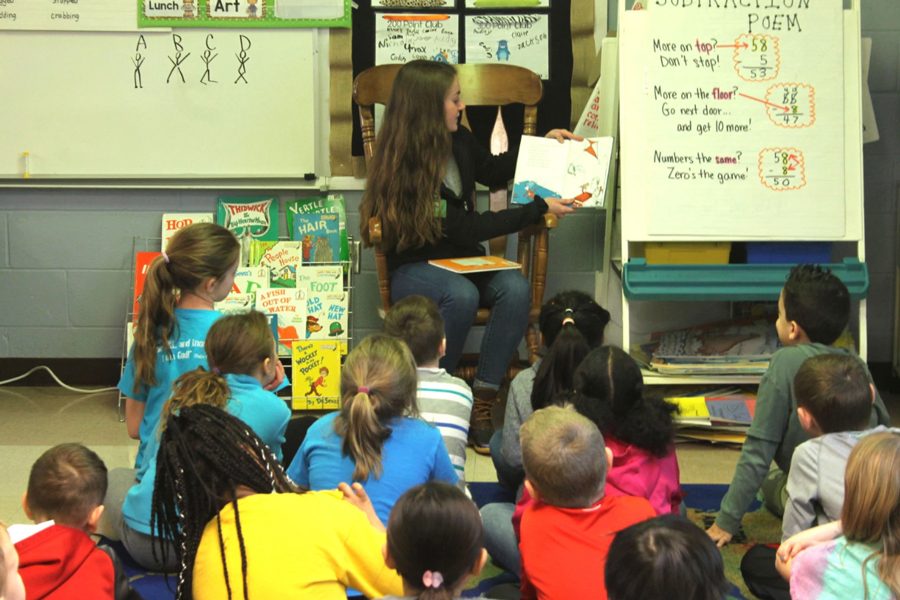 At Henderson Elementary in Mrs. Hackman's second grade class, senior Kelly Burris reads to the students on March 1. After class, students did many Dr. Seuss activities in their classrooms. NHS participants picked their favorite Dr. Seuss book to read to the classes. The teachers and staff were very excited to show that even the high schoolers from FHN find reading fun. ”These books are timeless and even enjoyable for the older kids,” Henderson Elementary librarian, Emily Gillet said.