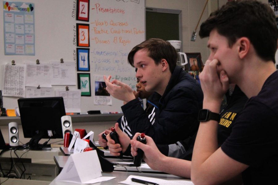 After thinking about the question, sophomore William Pundmann buzzes in to answer a question during a round. The buzzing system works much like Jeoprady, a TV game show where contestants buzz in to answer a question. If the contestant gets the question right, the team gets three bonus questions, which they can discuss to answer.