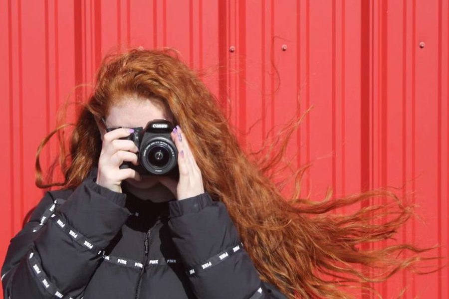 Senior Gabby Reed holds up her camera, ready to take a picture.