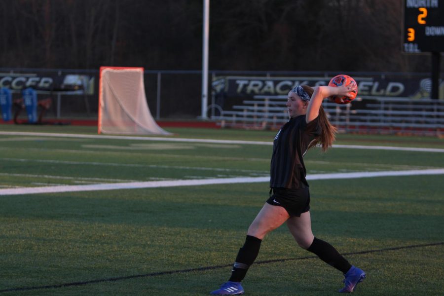 Senior Megan Crain throws the soccer ball back into the field of play.