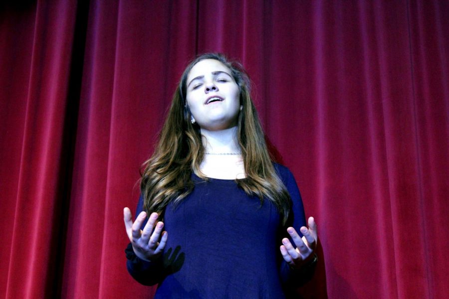 Sophomore Zoë Meier sings on the auditorium stage during her rehearsal for State Choir competition. Meier has been attending singing lessons since she was 12 and has been involved in musical theater since she was 8. She plans on continuing singing as a career in the future.