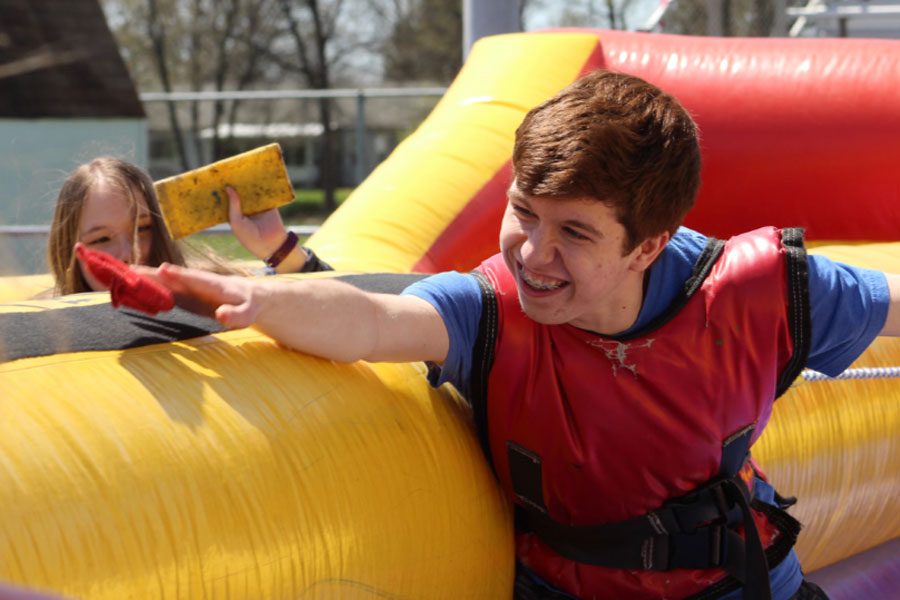 Junior Cameron Minter lunges to throw his bean bag to win the game. KOE hosted the KOE Picnic last year, with multiple bouncy castles. The picnic was for students who did good things within the school throughout the school year. 