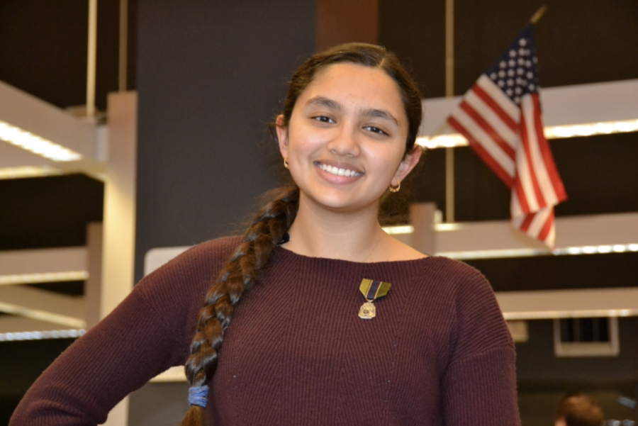 Junior Uma Upamaka poses with regional medal from the Americas Legion Oratorical Speech Competition.