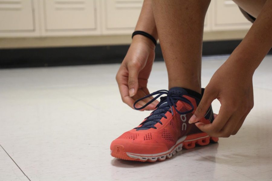 Junior Silvana Wang ties her shoe before she goes out for a run.