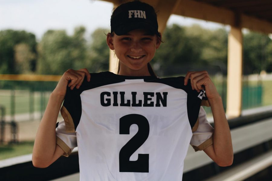 On the FHN’s softball field Jessica Gillen holds up her jersey for varsity on Sept. 21 to show her number. Gillen has been playing softball almost all her life, since she was five years old her parents would put her into little leagues. So she just decided to continue with softball and has loved it ever since.  “My parents wanted me to be active as a kid,” Gillen said.