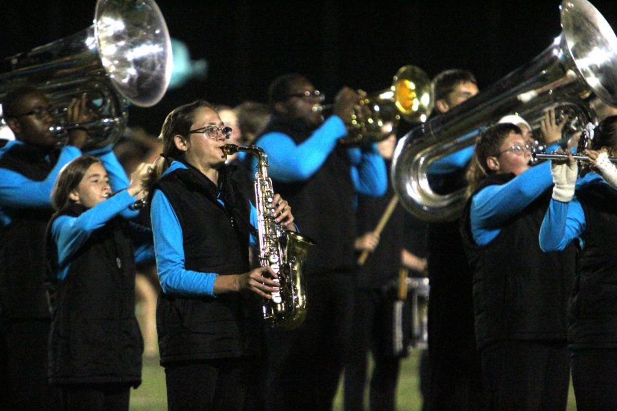 At the football game on Sept. 6, sophomore Rylie Miller plays the alto saxophone in Knightpride’s new marching band show, “Freeze.” This is Miller’s second show with the band. “I enjoy experiencing band memories with my friends,” Miller said. (Photo by Avery Witherbee)