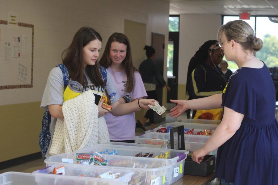 At the snack table, junior Brandi Stover hands money to a parent volunteer. The snack table has a variety of snacks for students and staff members to choose from. The money collected will go towards the Senior All-Knighter. (Photo by Allie Moore)