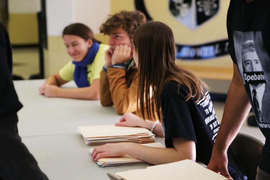 Emma Rohrbach converses with members of the Troy-Buchanan speech and debate team at the judges' table. Located at the front of the school, this table is responsible for checking schools in, directing judges to rooms, and ensuring the tournament runs smoothly overall. 