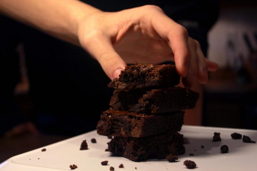 A hand reaches for a plate of brownies. The Board of Education will host an event called Brownies with the Board. The event will be held at the FHSD Admin building on Jan. 23. (Photo by Addy Bradbury)