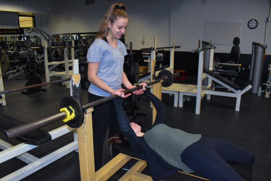 On Feb. 21, freshman Maddie Swart spots sophomore Sydnee Williams in FHN’s weight room to build up strength in preparation for girls’ lacrosse season. Both athletes have at least three years of experience, and have been putting a lot of time and effort into their sport specific skills and pre-season workouts.