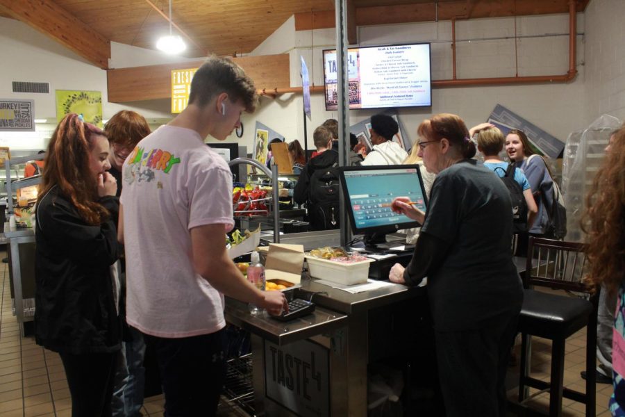 Junior Justin Baniak pays for his lunch after getting his food. The lunchroom has a variety of choices for lunch from nachos to ramen daily. Groups of teachers and students went on trips to research power lunches first hand to figure out how to apply them to FHN. (Photos by Pavan Kolluru)