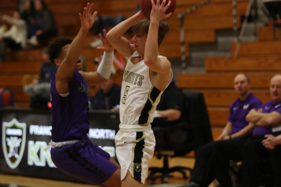 Senior Ben Oster yanks the ball above his head to avoid his opponent from taking it. 
