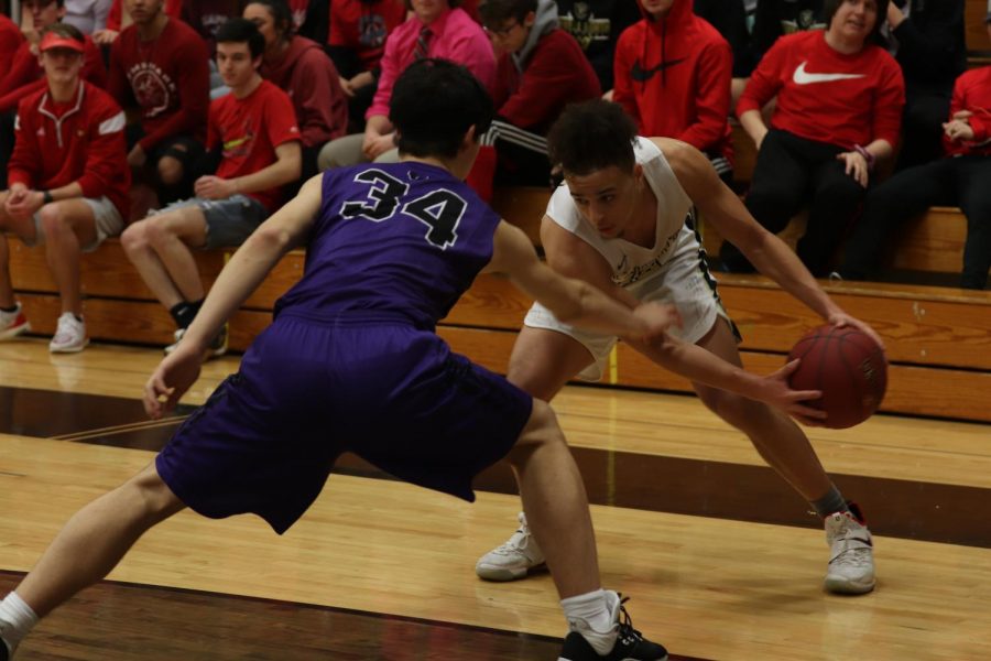 Senior Cameron Lewis looks to pass the ball while trying to avoid the opponent from stealing it away.
