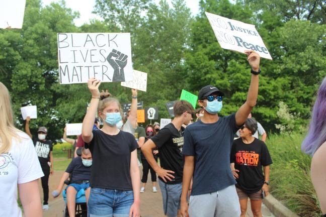 Protestors hold signs at the St. Charles protest held this summer in support of the Black Lives Matter movement and against police brutality.