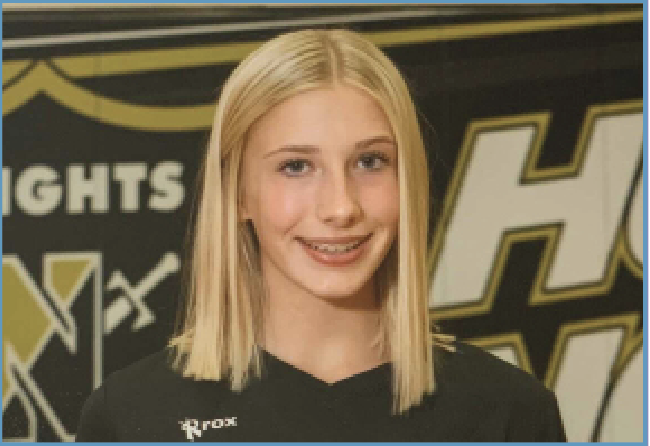 Freshman, Jada Keller smiles at the camera in the school's gym wearing her Knights volleyball uniform. 