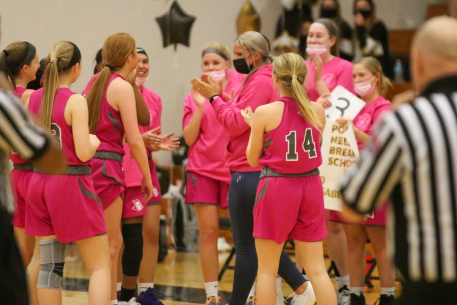 The Lady Knights celebrate with senior Isabelle Delarue at the game. Delarue set a new record for points scored in FHN girls' basketball.