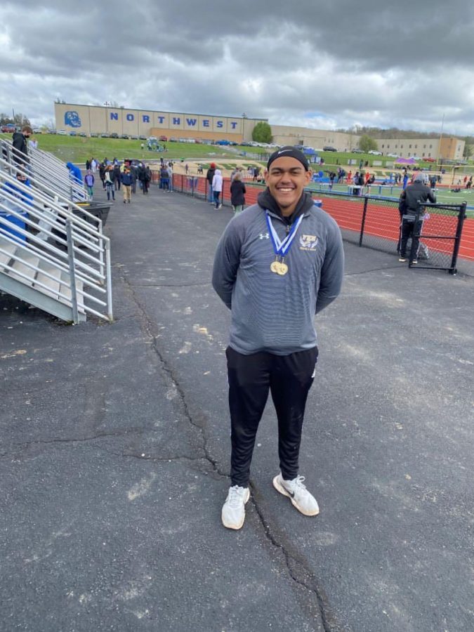 Senior Aaron Okello poses with medals after receiving first place in both boys varsity shotput and discus, at Northwest Invitational. 