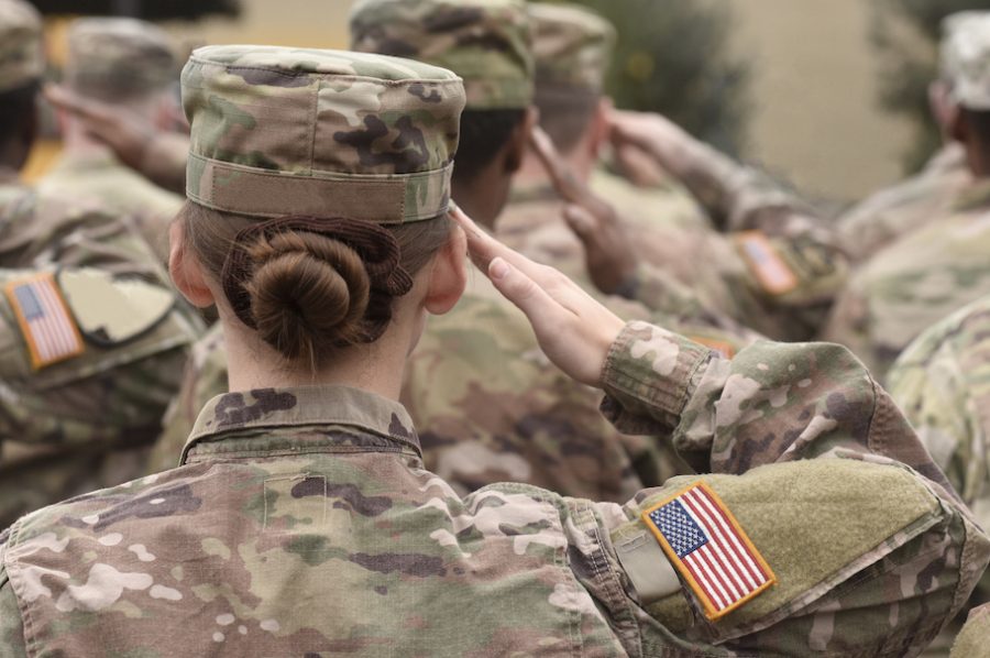 Female American Army soldier salutes in the lineup. (Photo from shutterstock) 