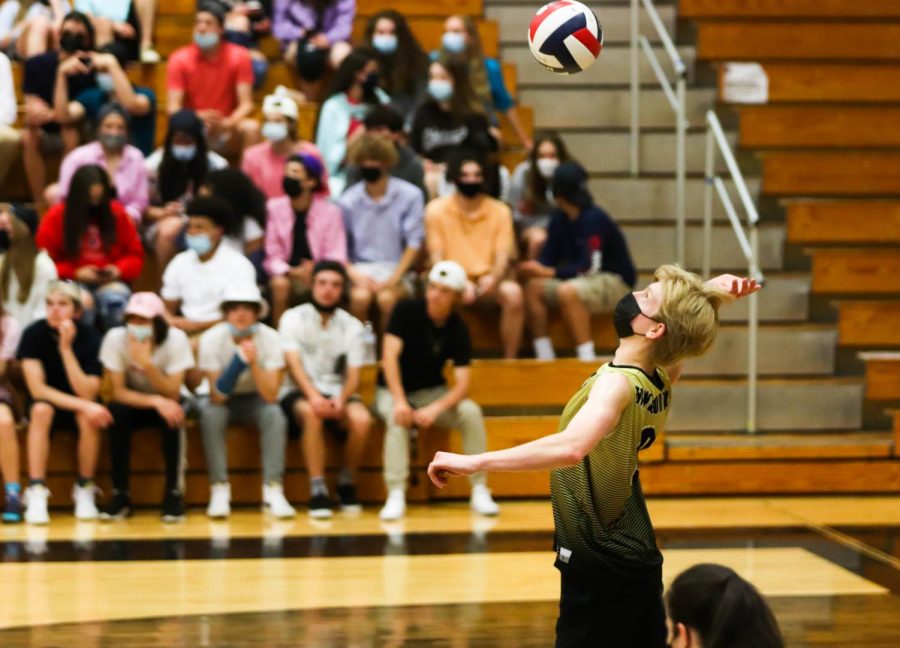 Senior Cole Hopper jumps to hit the volleyball during a game