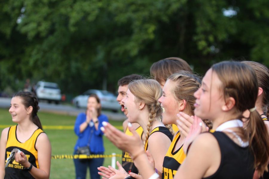 The cross country team cheers on their teammates.