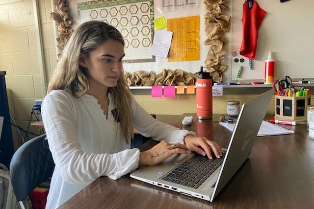 New teacher Rowan Pugh sits at her desk in her classroom