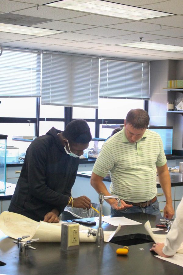 Science teacher Joseph Brocksmith helps one of his students working with a topographical map.