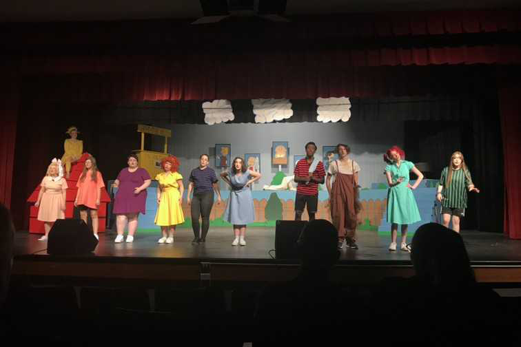 The cast of "You're a Good Man, Charlie Brown" stands on the stage together.