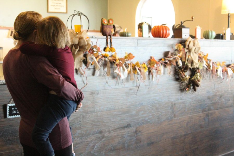 A woman and her child waits for her drink at the counter.