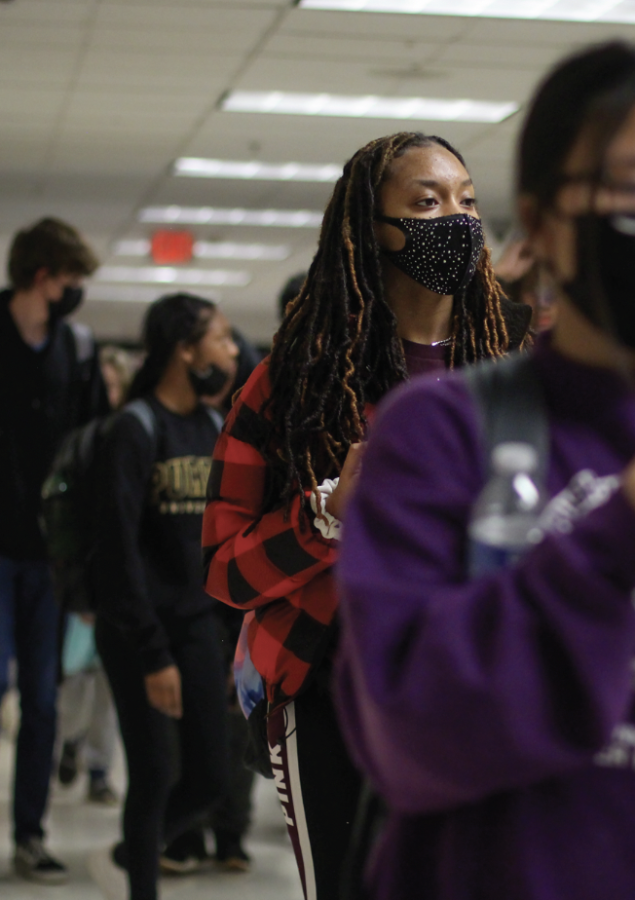 Students walk to class on Nov. 17, some with masks, and some without. The mask policy in the building was changed to be optional, as compared to last year where it was required.