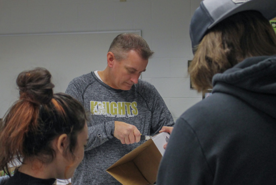 Business teacher Mike Freedline helps students in a class project