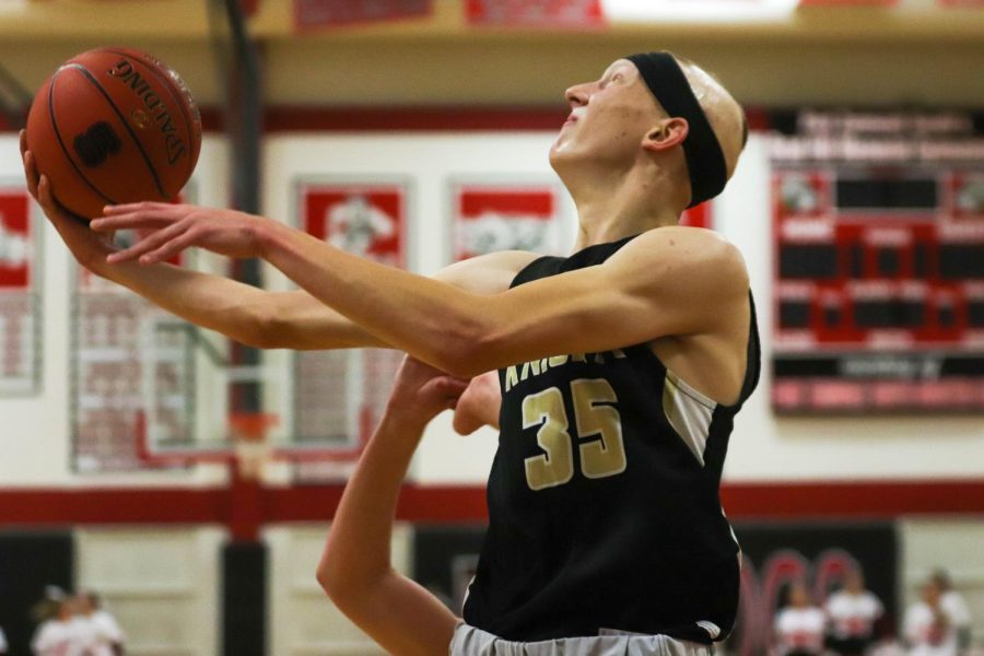 Junior Ryan Murdock jumps to dunk the ball during a basketball game 