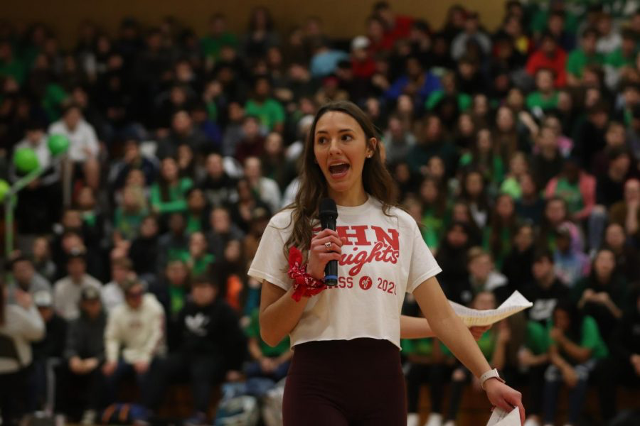 Senior Paige Vanek, an emcee for the Snowcoming pep assembly, tells the crowd about a game they will be playing, musical chairs.