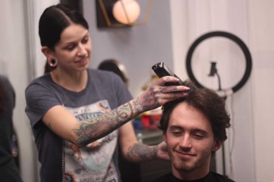 Patrick Faulkner smiles as he gets his head shaved for canver awareness on March 5. In support of his younger friend, Faulkner raised $353 for the cause. (Photo by Kylie Taliaferro)