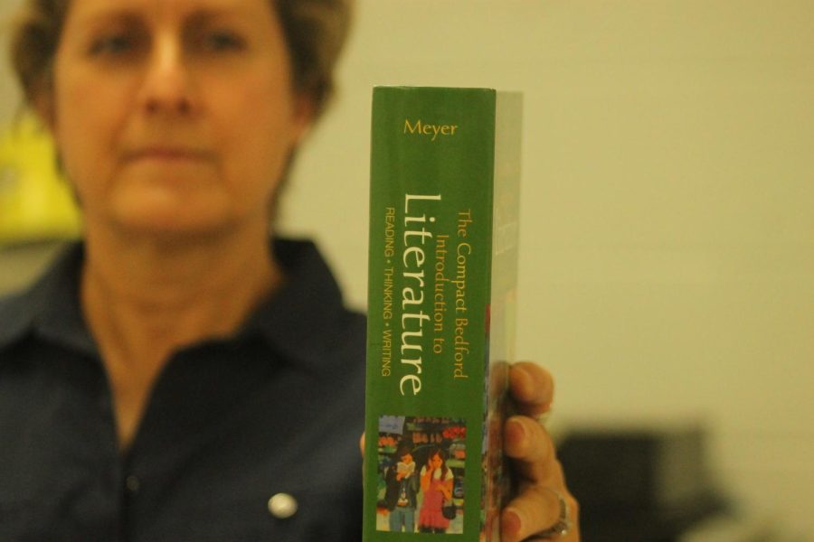 In her classroom, English teacher Amy Stoker reads a textbook she uses in her AP English Literature and Composition class.  
