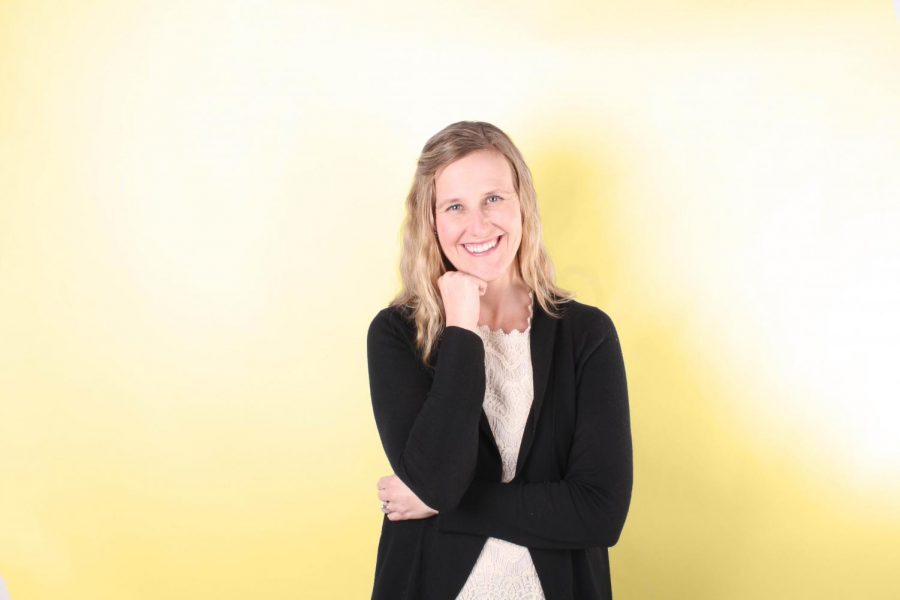 Shelly Parks poses for a photo in front of a yellow backdrop. 