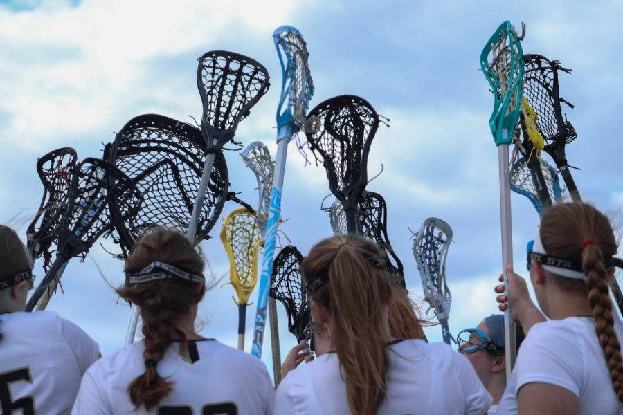 Members of FHNs girls lacrosse teams hold up lacrosse sticks as a cheer before playing on April 6th. The game was against Incarnate Word Academy and had an end score of 13-11 with Incarnate Word winning. 