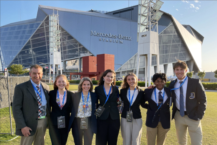 DECA sponsor Mike Freedline, Rachel Buchanan, Bailey Scarbrough, Natalie Stevens, Ellie Lichty, Pavan Kolluru, and Joey Key pose for a photo during DECA internationals. (