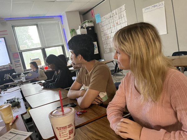 Students listen to a speaker in a speech and debate session. 