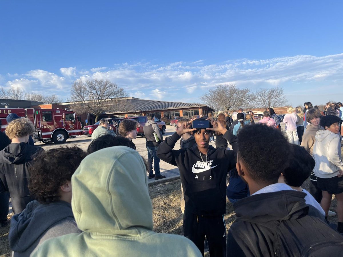 Students socialize and play games on their phone to pass time during the fire drill.