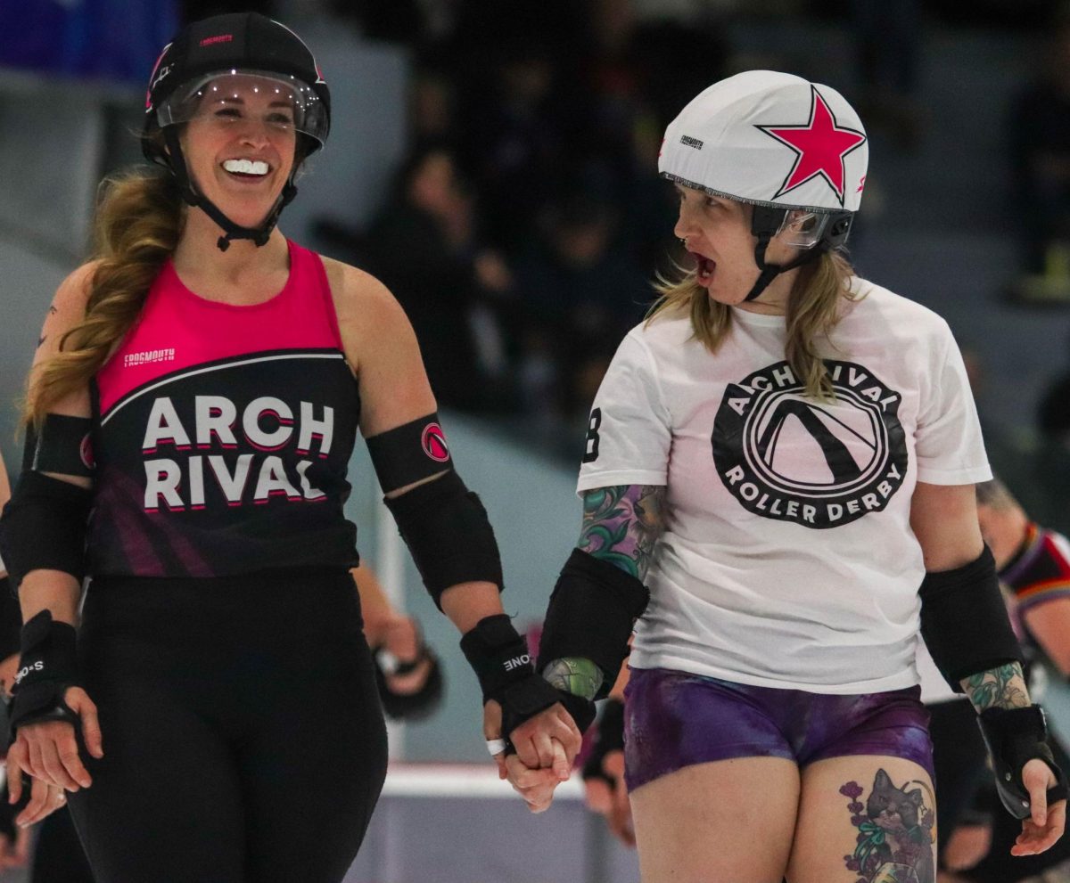 Two jammers hold hands as one gasps at something the other said after a jam ends during a scrimmage between the black and white teams on Feb. 17. Typically, roller derby games will be between two different teams, but for ARCH's season opener, they played scrimmages within their league, meaning those who are usually teammates could be playing against each other. ARCH is a large league with three women's teams, one junior team and an affiliated men's league known as the Gatekeepers.

“It's an immediate group of friends that you have from day one, which is really cool,” ARCH player Carol Hopfinger said. “Especially as an adult, it's hard to make friends, it's just a weird situation, but it's immediate as soon as you step on the track.”
