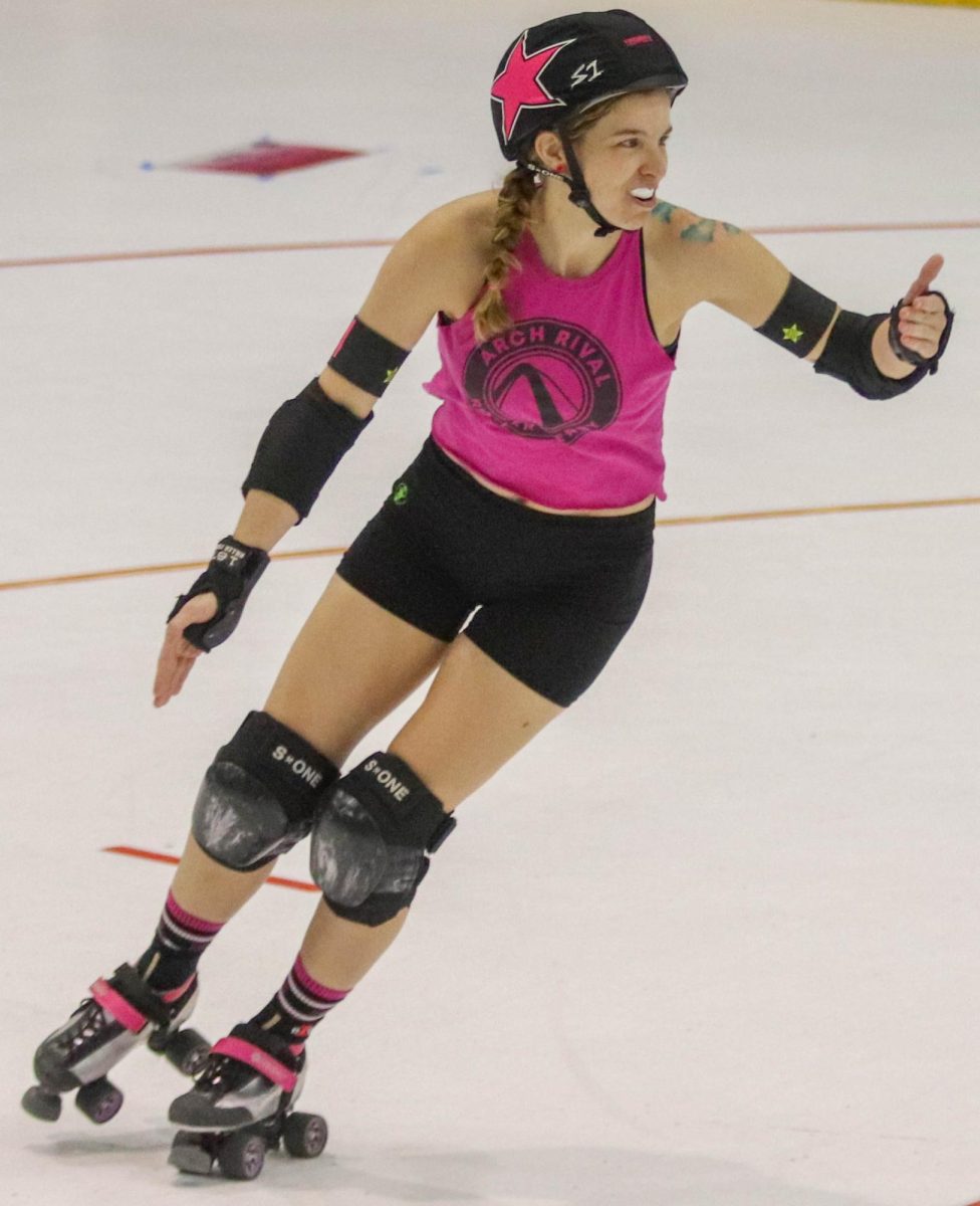 Beth Henry, whose derby name is Jedi, skates around the track during the final scrimmage of the night on Feb. 17. During this jam, Henry was the lead jammer, so she held up her thumb to let the blockers on her team know what to do. Roller derby is a demanding sport, but players find it rewarding nonetheless. 

"Attending practice two or three times a week is another time that could be spent relaxing," first year skater Rabia Polzin said. "But if it's between laying at home or getting in shape and being around people and community, it's a great trade off, frankly."
